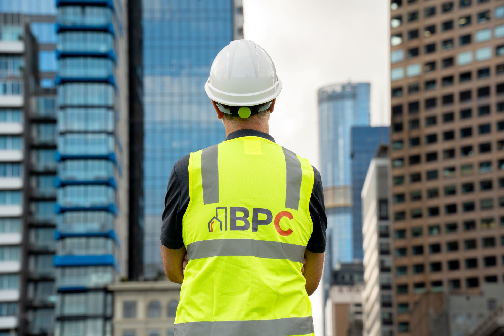 Worker wearing a BPC hi-vis vest looking at city