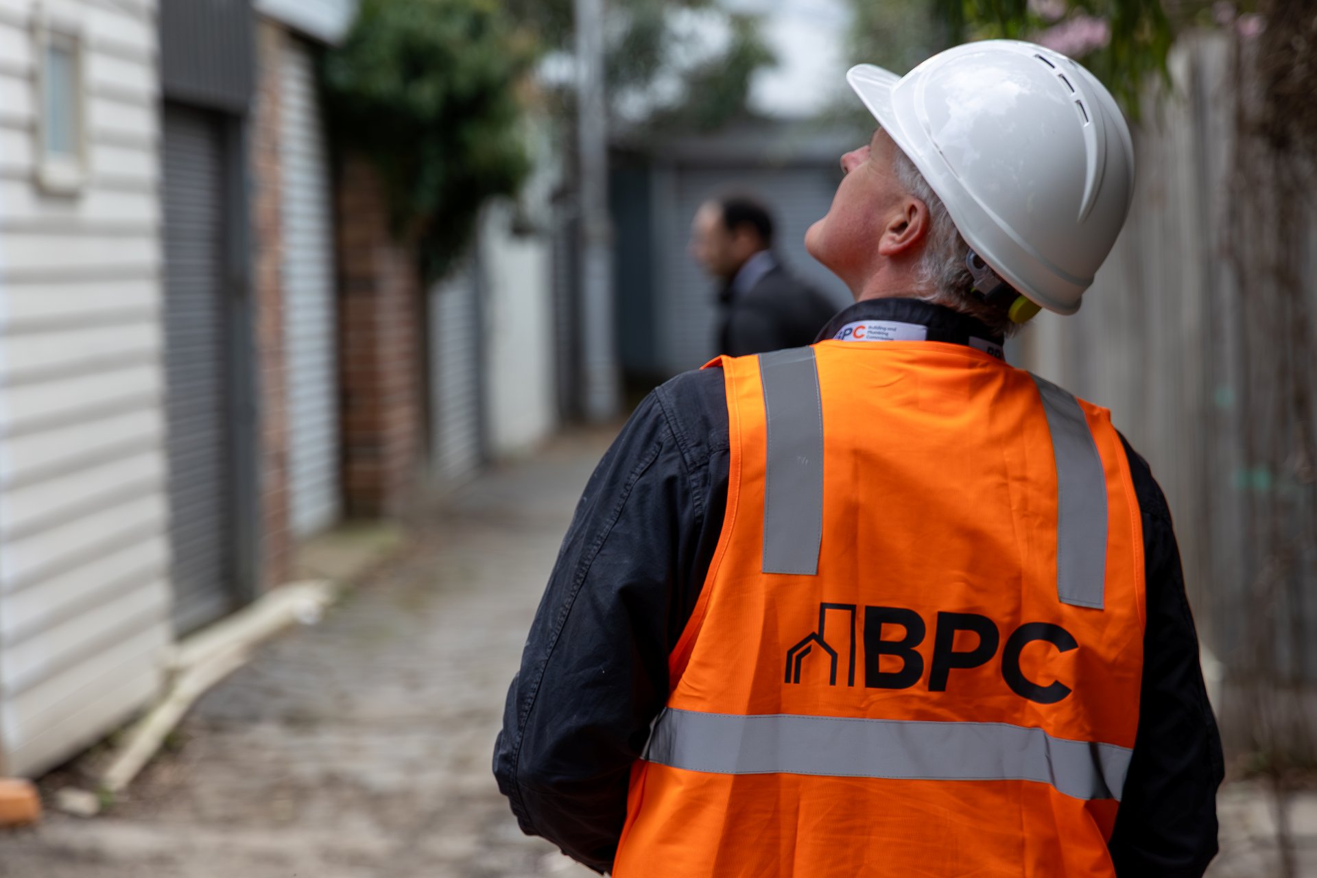 BPC inspector wearing a hi-vis vest looking at property