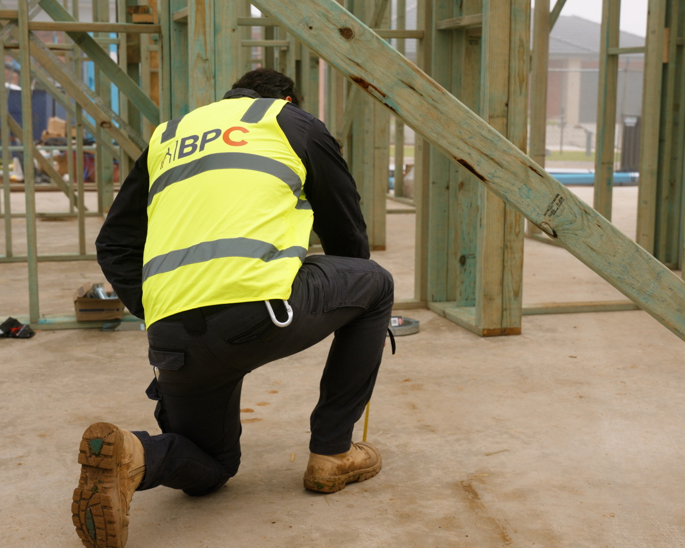 BPC Inspector with Hi-Viz kneeling on one knee