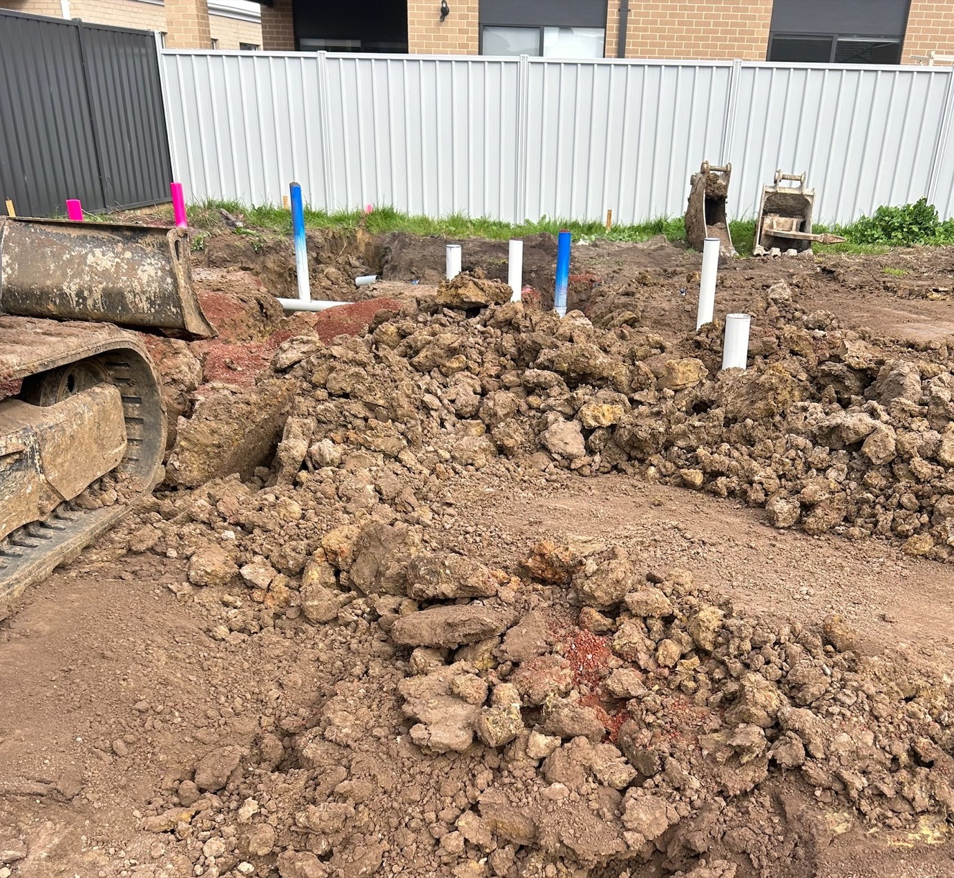 worksite showing plumbing wells and a digger