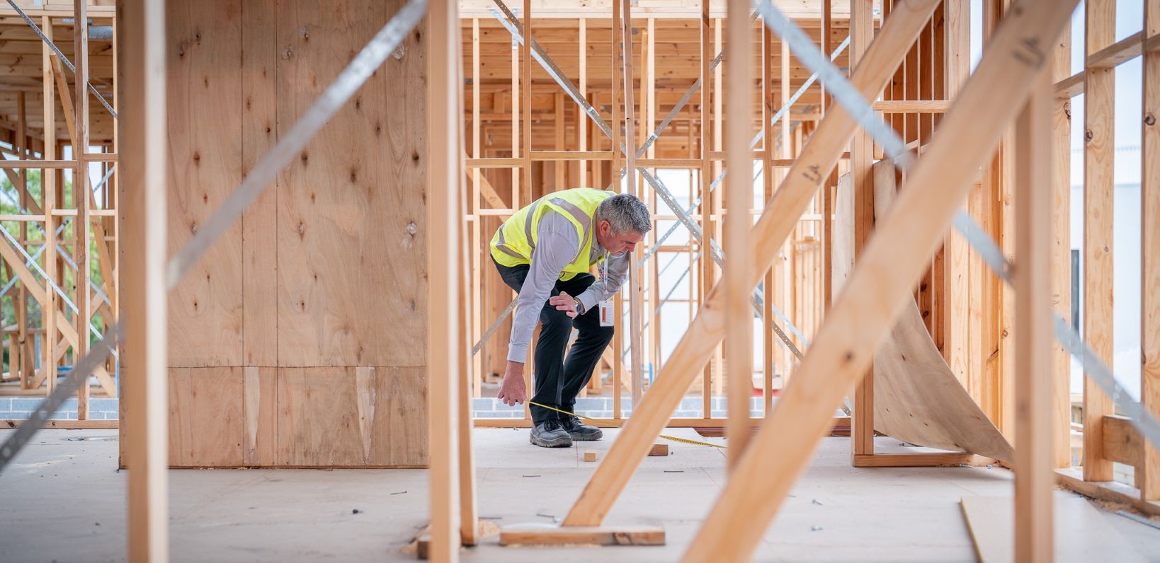 BPC inspector using tape measure on floor